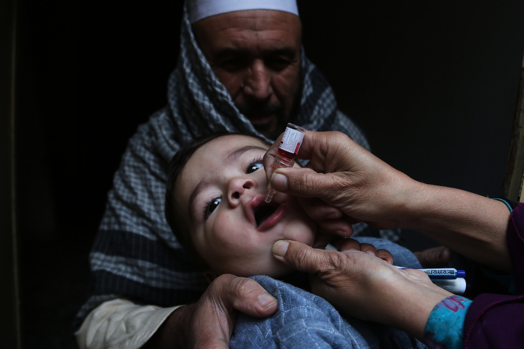 A health worker administers a polio vaccine to a child at a neighbourhood in Peshawar, Pakistan, Monday, Monday, Dec. 15, 2025. (AP Photo/Muhammad Sajjad)