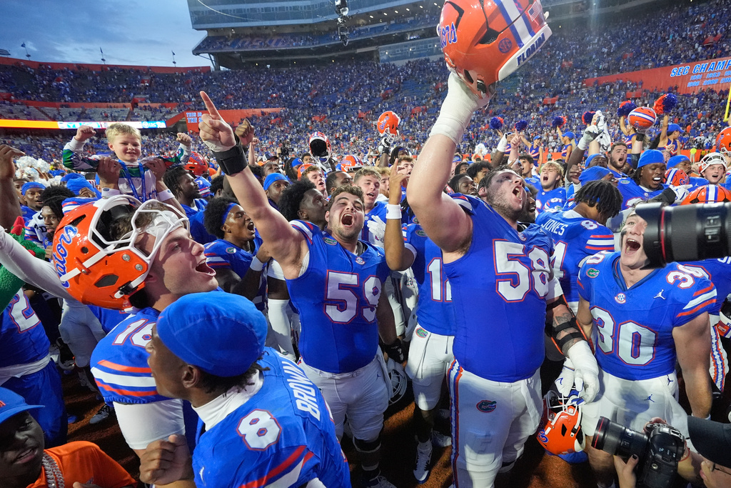 Florida players celebrate after defeating Texas in an NCAA college football game, Saturday, Oct. 4, 2025, in Gainesville, Fla. (AP Photo/John Raoux)