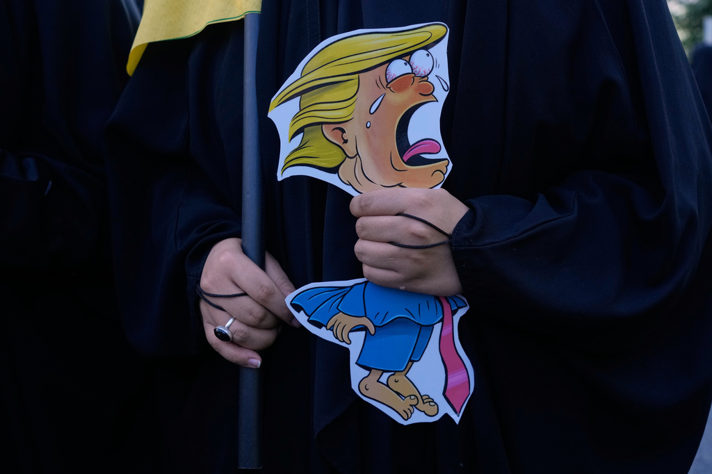 A woman holds a caricature of U.S. President Donald Trump as she attends the state-organized "Janfada," or "Sacrifice for Iran," military-style parade in Tehran, Iran, Friday, Sept. 18, 2026. (AP Photo/Vahid Salemi)