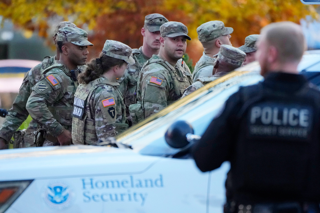 Members of the National Guard gather after reports of two National Guard soldiers were shot near the White House in Washington, Wednesday, Nov. 26, 2025. (AP Photo/Mark Schiefelbein)