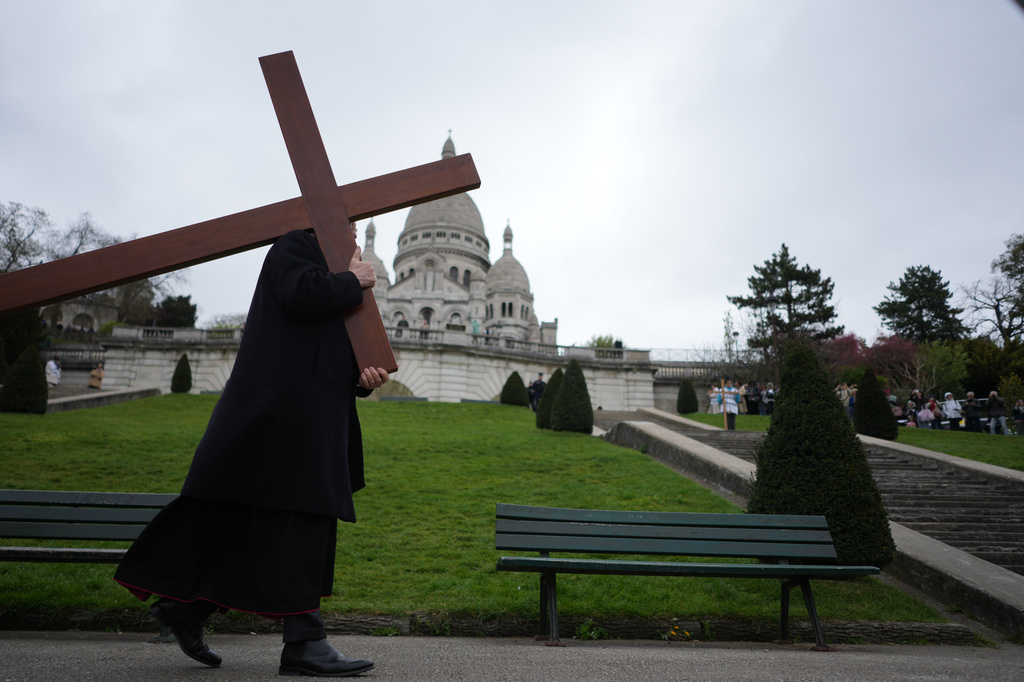Paris Archbishop Laurent Ulrich, carries the cross during the Way of Cross ceremony to mark Good Friday, outside the Sacre Coeur basilica, in Paris, Friday, April 3, 2026 . (AP Photo/Thibault Camus)