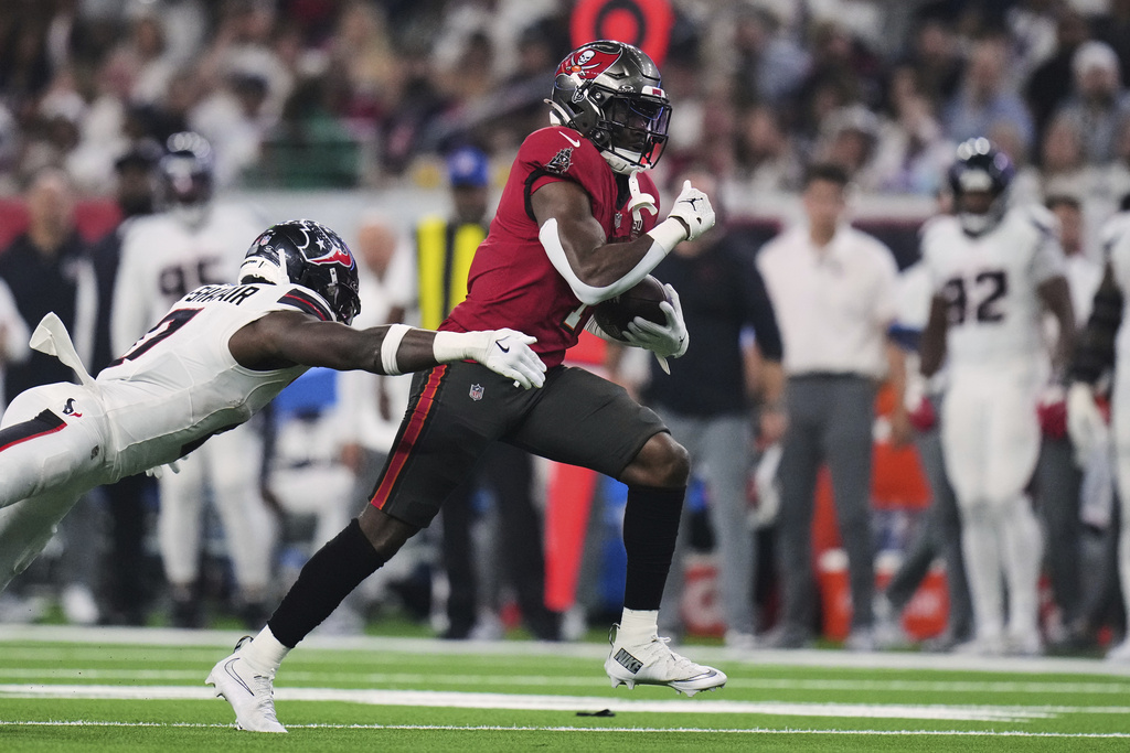 Tampa Bay Buccaneers running back Rachaad White (1) gains yards after a catch as Houston Texans linebacker Azeez Al-Shaair, left, makes the stop in the second half of an NFL football game Monday, Sept. 15, 2025, in Houston, Texas. (AP Photo/Eric Gay)