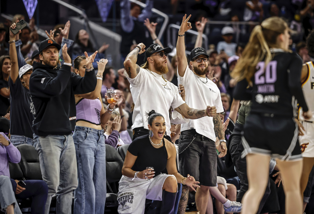 San Francisco 49ers NFL football players George Kittle, third from left, Ricky Pearsall, right, and Kyle Juszczyk, left, cheer on the sideline in the first half of a WNBA basketball game as the Golden State Valkyries play the Indiana Fever in San Francisco, Sunday, Aug. 31, 2025. (Carlos Avila Gonzalez/San Francisco Chronicle via AP)