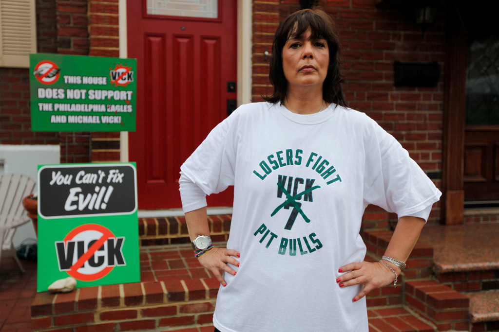 FILE - In this photo taken Sept. 30, 2010, Monica Caraffa poses for a photo with signs in front of her home opposing Philadelphia Eagles quarterback Michael Vick, in Philadelphia. (AP Photo/Matt Rourke, file)