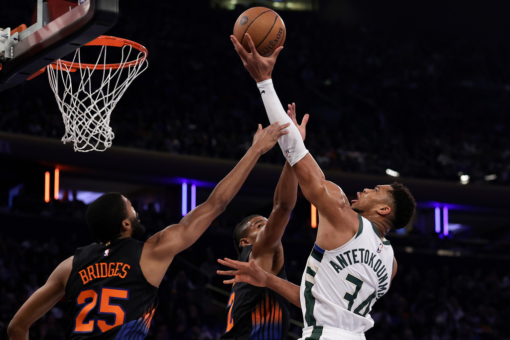 Milwaukee Bucks forward Giannis Antetokounmpo, right, drives to the basket against New York Knicks guard Mikal Bridges (25) during the first half of an NBA basketball game, Friday, Nov. 28, 2025, in New York. (AP Photo/Adam Hunger)