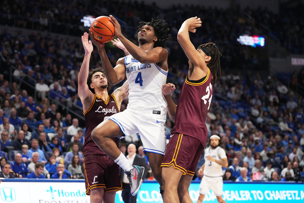 Saint Louis' Amari McCottry (4) heads to the basket past Loyola Chicago's Deywilk Tavarez, left, and Miles Rubin, right during the second half of an NCAA college basketball game Wednesday, March 4, 2026, in St. Louis. (AP Photo/Jeff Roberson)