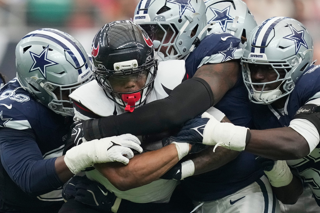 Houston Texans running back David Montgomery is hauled down by Dallas Cowboys defenders during the second half of an NFL football game in Houston, Sunday, Oct. 4, 2026. (AP Photo/Ashley Landis)