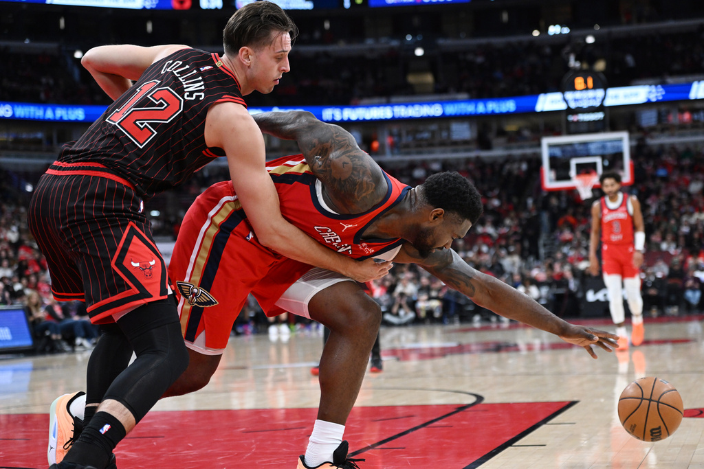 New Orleans Pelicans' Zion Williamson, right, battles Chicago Bulls' Zach Collins (12) for the ball during the first half of an NBA basketball game Sunday, Dec. 14, 2025, in Chicago. (AP Photo/Paul Beaty)