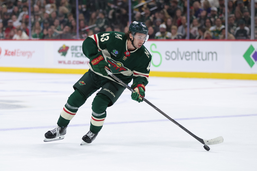 Minnesota Wild defenseman Quinn Hughes skates with the puck during the first period of an NHL hockey game against the Boston Bruins, Saturday, Oct. 3, 2026, in St. Paul, Minn. (AP Photo/Bailey Hillesheim)