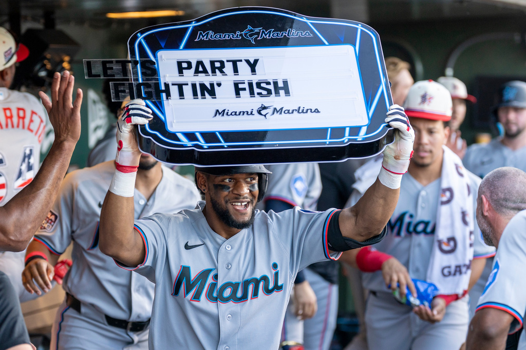 Miami Marlins' Otto Lopez, center, celebrates in the dugout after hitting a two-run home run during the third inning of a baseball game against the Athletics, Saturday, July 4, 2026, in West Sacramento, Calif. (AP Photo/Sara Nevis)