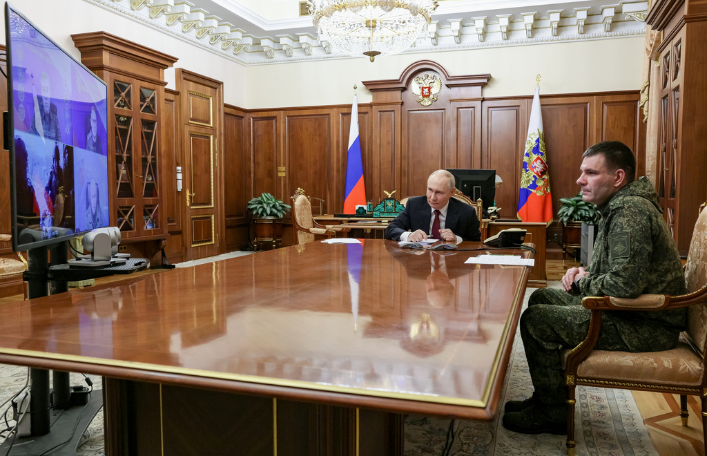 Russian President Vladimir Putin, center, holds a call with military leaders on the Ukraine battlefield situation together with Denis Pirogov, right, a Russian army brigade commander, at the Kremlin in Moscow, on Thursday, Dec. 11, 2025. (Gavriil Grigorov, Sputnik, Kremlin Pool Photo via AP)