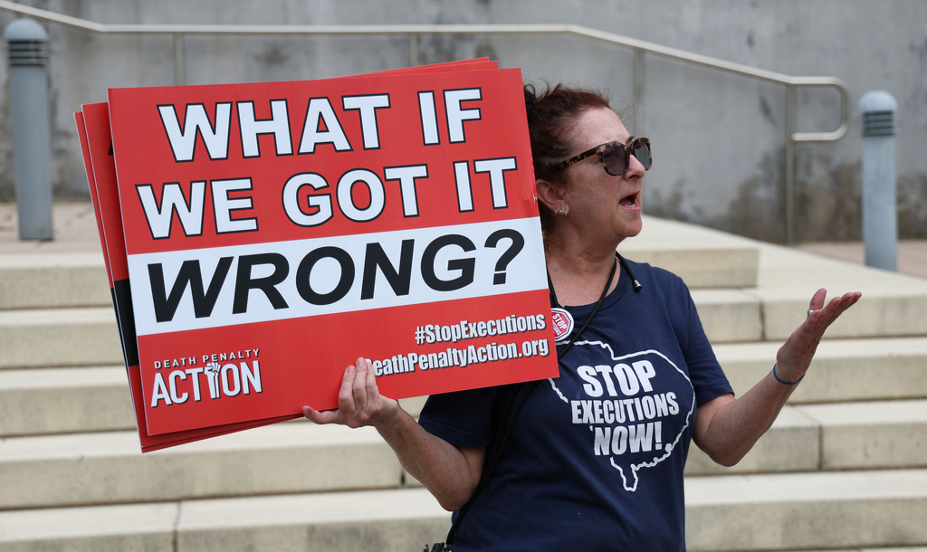 Death penalty protester SueZann Bosler holds a sign during a demonstration in front of the Lake County Courthouse in Tavares, Fla., Tuesday, July 28, 2026. (Joe Burbank/Orlando Sentinel via AP)