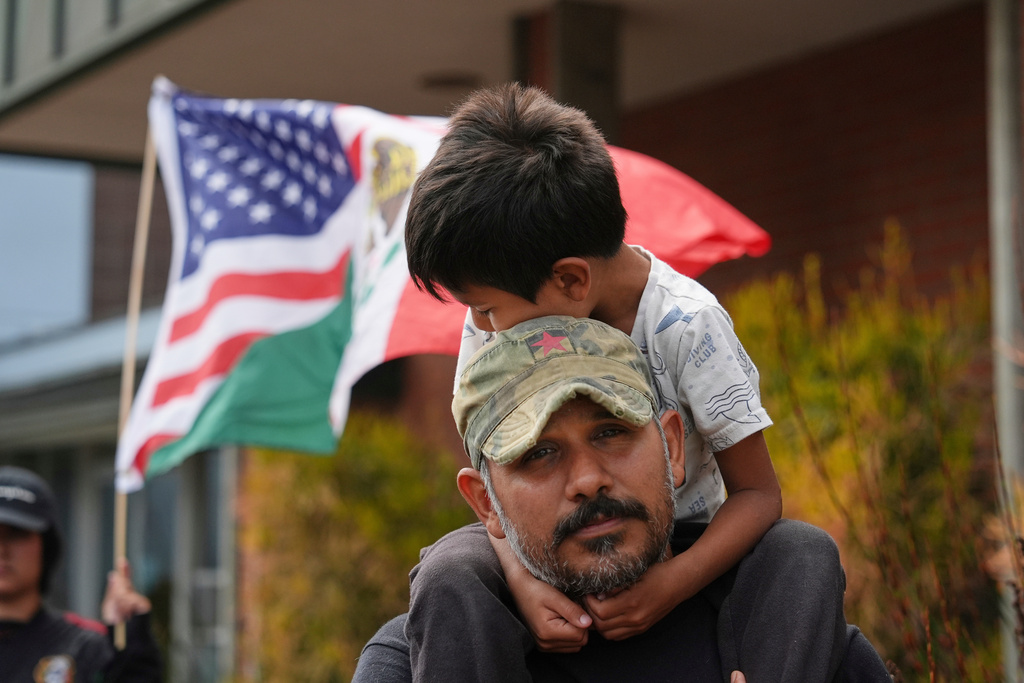 FILE - Gerardo Santos lifts his son Xavier, 5, on his shoulders during a protest in reaction to immigration raids, July 11, 2025, in Oxnard, Calif. (AP Photo/Jae C. Hong, File)