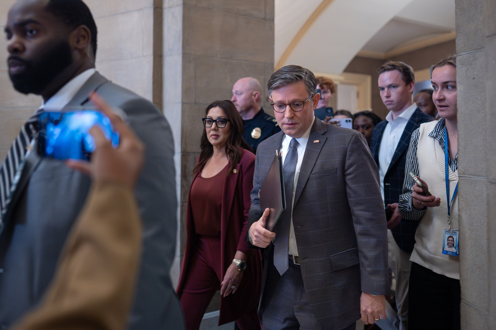 Speaker of the House Mike Johnson, R-La., center, joined by Secretary of Labor Lori Chavez-DeRemer, left, returns to his office after meeting with reporters on day 35 of the government shutdown, at the Capitol in Washington, Tuesday, Nov. 4, 2025. (AP Photo/J. Scott Applewhite)