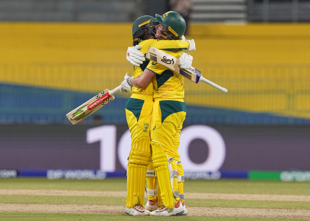 Australia's Beth Mooney, right, celebrates her century with Alana King during the ICC Women's Cricket World Cup match between Australia and Pakistan at Premadasa Stadium in Colombo, Sri Lanka, Wednesday, Oct, 8, 2025. (AP Photo/Eranga Jayawardena)