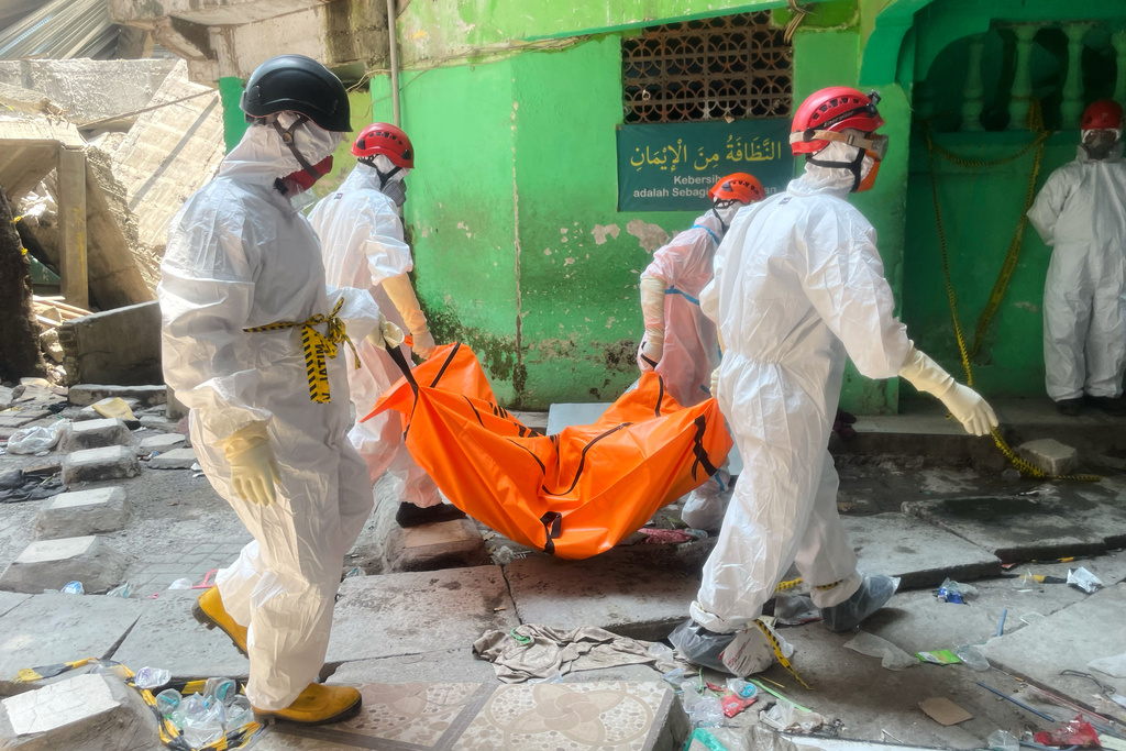 Rescuers carry the body of a victim after an Islamic boarding school collapsed in Sidoarjo, East Java, Indonesia, Friday, Oct. 3, 2025. (AP Photo/Trisnadi)
