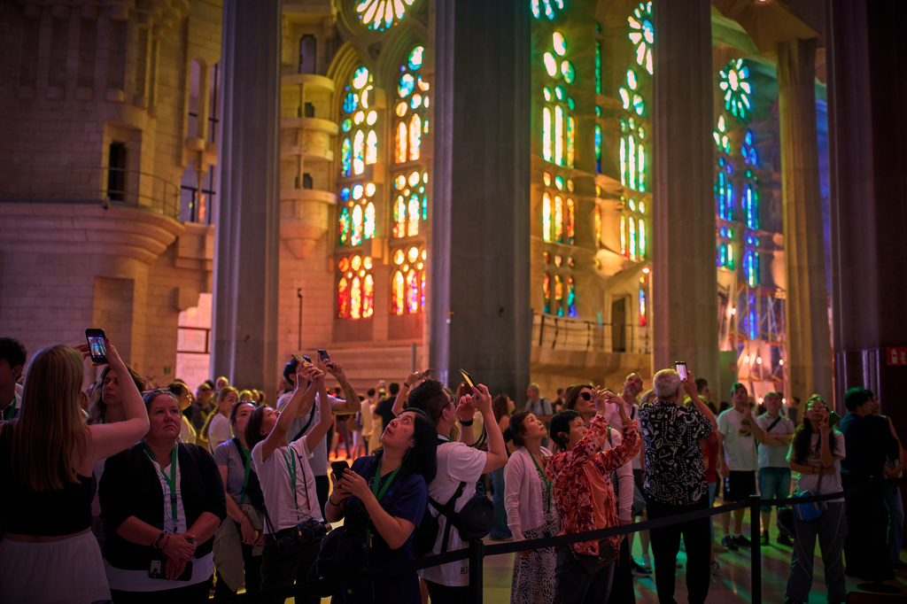 Visitors take photos inside the Basilica of the Sagrada Familia in Barcelona, Spain, Tuesday, May 26, 2026, ahead of Pope Leo XIV's visit to the city in June. (AP Photo/Emilio Morenatti)
