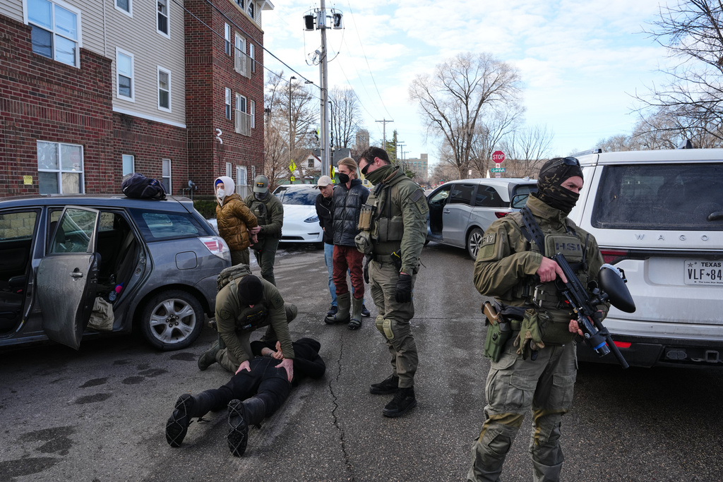 Protesters are detained by federal immigration officers Monday, Jan. 12, 2026, in Minneapolis. (AP Photo/Adam Gray)