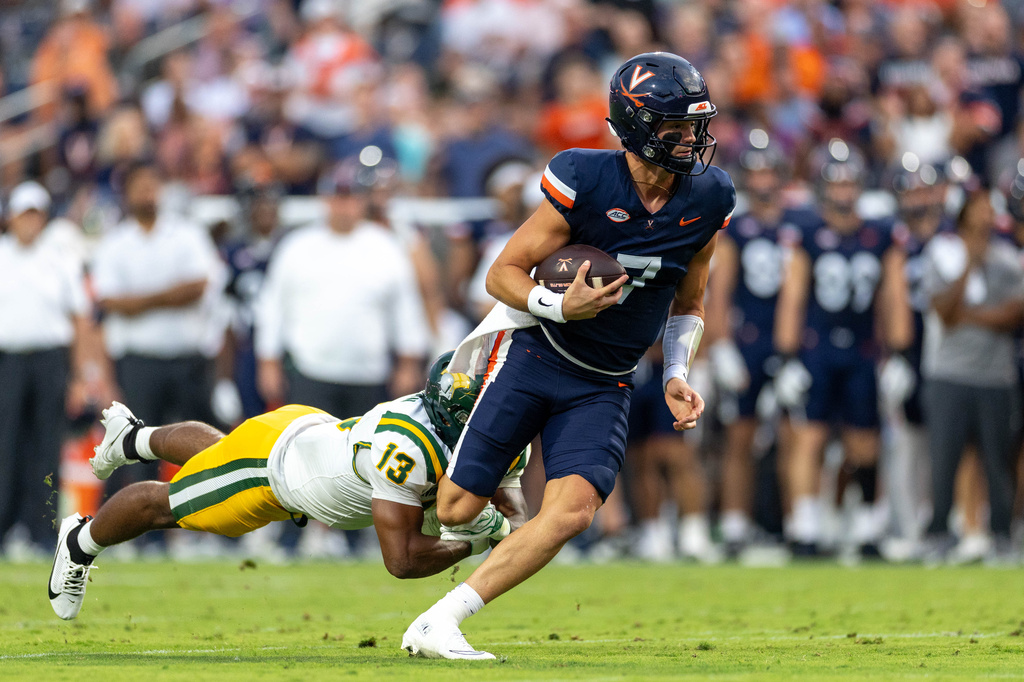 Virginia quarterback Beau Pribula (7) is tackled by Norfolk State linebacker Brendan Thompson (13) during an NCAA college football on Friday, Sept. 11, 2026, in Charlottesville, VA. (AP Photo/Mike Kropf)