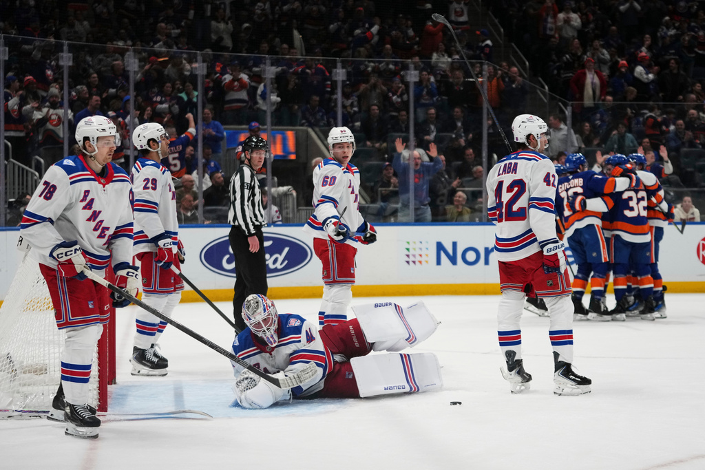 New York Rangers goaltender Spencer Martin, Brennan Othmann (78), Matthew Robertson (29), Scott Morrow (60) and Noah Laba (42) react as the New York Islanders celebrate a goal by Jean-Gabriel Pageau during the second period of an NHL hockey game Wednesday, Jan. 28, 2026, in Elmont, N.Y. (AP Photo/Frank Franklin II)