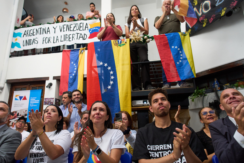 People applaud while watching the ceremony of the Nobel Peace Prize for Venezuelan opposition leader Maria Corina Machado in Norway, during a live viewing in Buenos Aires, Argentina, Wednesday, Dec. 10, 2025. (AP Photo/Rodrigo Abd)