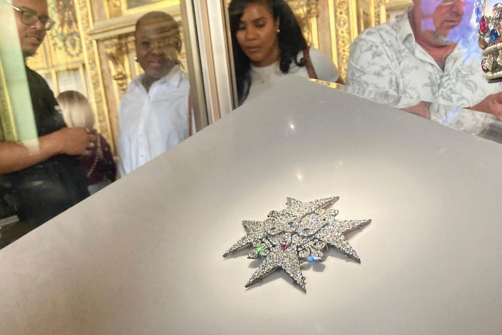 FILE - Visitors look at jewelry in the Apollo Gallery of the Louvre museum on Sept. 4, 2025, in Paris. (AP Photo/Alexander Turnbull, File)