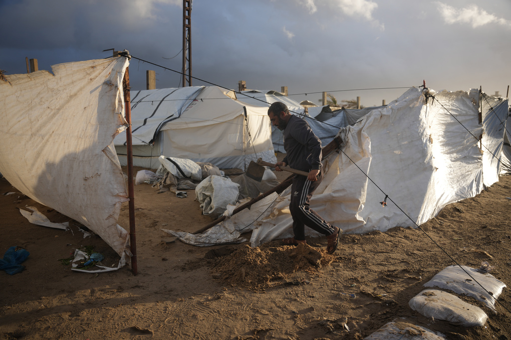 Khaled Abu Jazar, 53, reinforces his tent after it was damaged by stormy weather at a tent camp in Deir al-Balah, in the central Gaza Strip, Friday, Jan. 9, 2026. (AP Photo/Abdel Kareem Hana)