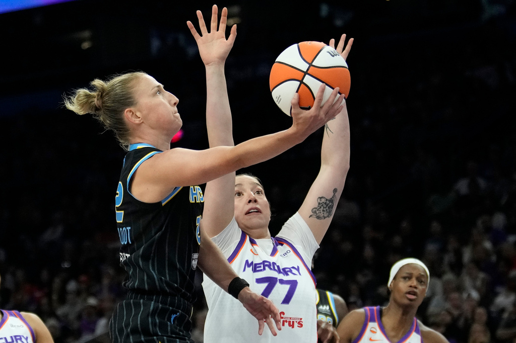 Chicago Sky guard Courtney Vandersloot, left, drives past Phoenix Mercury center Marta Suarez (77) to score during the second half of a WNBA basketball game, Tuesday, July 7, 2026, in Phoenix. (AP Photo/Ross D. Franklin)