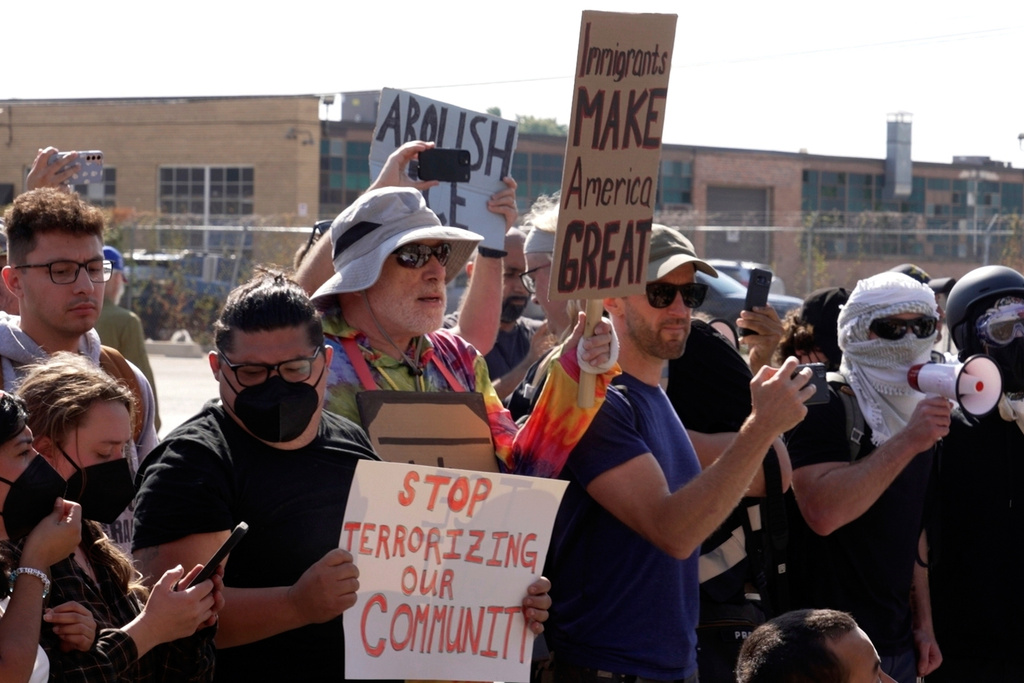 People protest outside of an immigration facility guarded by federal agents Friday, Sept. 12, 2025, in in Broadview, Ill. (AP Photo/Laura Bargfeld)