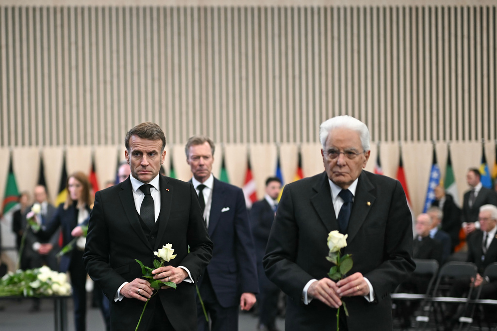 France's President Emmanuel Macron, left, and Italy's President Sergio Mattarella walk with white roses after the tribute ceremony for the victims of the deadly fire that ripped through the bar Le Constellation in Crans-Montana on New Year's Eve, in Martigny, Switzerland, Friday, Jan. 9, 2026. (Fabrice Coffrini/Pool Photo via AP)