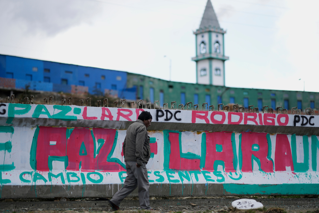 A man walks past a mural promoting presidential candidate Rodrigo Paz days ahead of the runoff election, in El Alto, Bolivia, Thursday, Oct. 16, 2025. (AP Photo/Natacha Pisarenko)