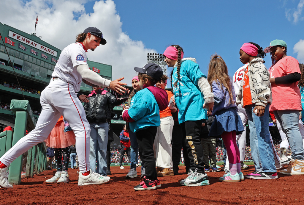 Boston Red Sox' outfielder Jarren Duran runs a gauntlet of young fans as he heads onto the field for the start of a baseball game against the Detroit Tigers, Monday, April 20, 2026 in Boston. (AP Photo/Jim Davis)