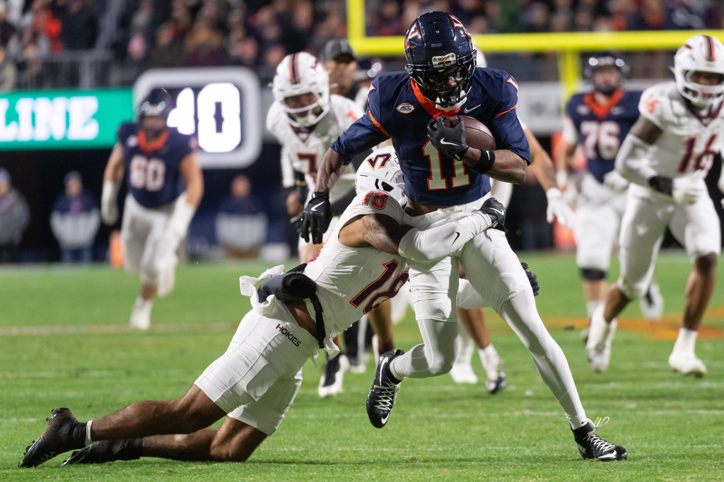 Virginia Tech safety Isaiah Cash (18) tackles Virginia wide receiver Trell Harris (11) during the first half of an NCAA college football game, Saturday, Nov. 29, 2025, in Charlottesville, Va. (AP Photo/Robert Simmons)