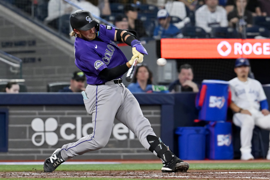 Colorado Rockies' Hunter Goodman hits a single in fifth-inning baseball game action against the Toronto Blue Jays in Toronto, Monday, March 30, 2026. (Jon Blacker/The Canadian Press via AP)