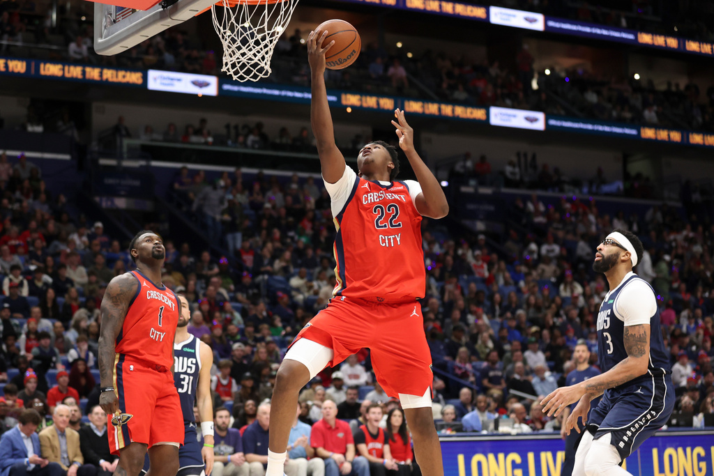 New Orleans Pelicans center Derik Queen (22) drives past Dallas Mavericks forward Anthony Davis (3) for a layup in the first half of an NBA basketball game Monday, Dec. 22, 2025, in New Orleans. (AP Photo/Peter Forest)