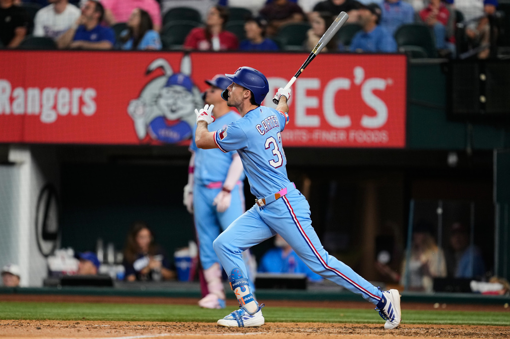 Texas Rangers' Evan Carter follows through on a two-run home run in the eighth inning of a baseball game against the Chicago Cubs Sunday May 10, 2026, in Arlington, Texas. (AP Photo/Tony Gutierrez)