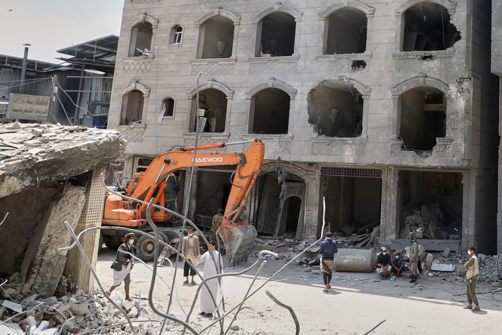 People gather at a damaged building following Israeli airstrikes in Sanaa, Yemen, Friday, Sept. 26, 2025. (AP Photo)