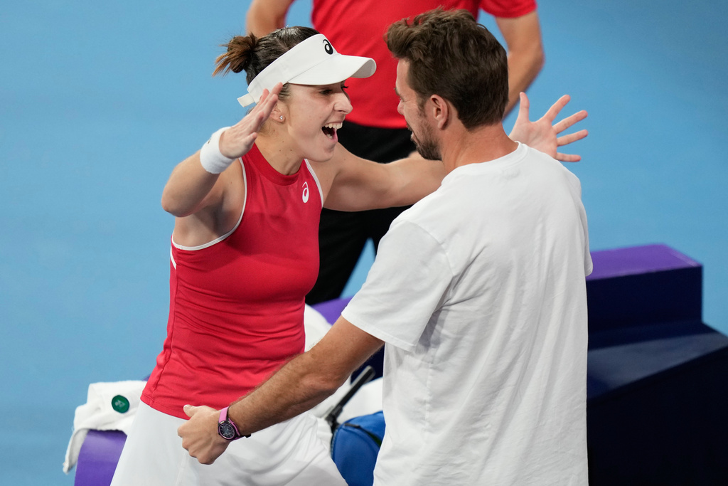 Belinda Bencic of Switzerland, left, celebrates with teammate Stan Wawrinka after defeting Iga Swiatek of Poland in their final match at the United Cup tennis tournament in Sydney, Sunday, Jan. 11, 2026. (AP Photo/Rick Rycroft)