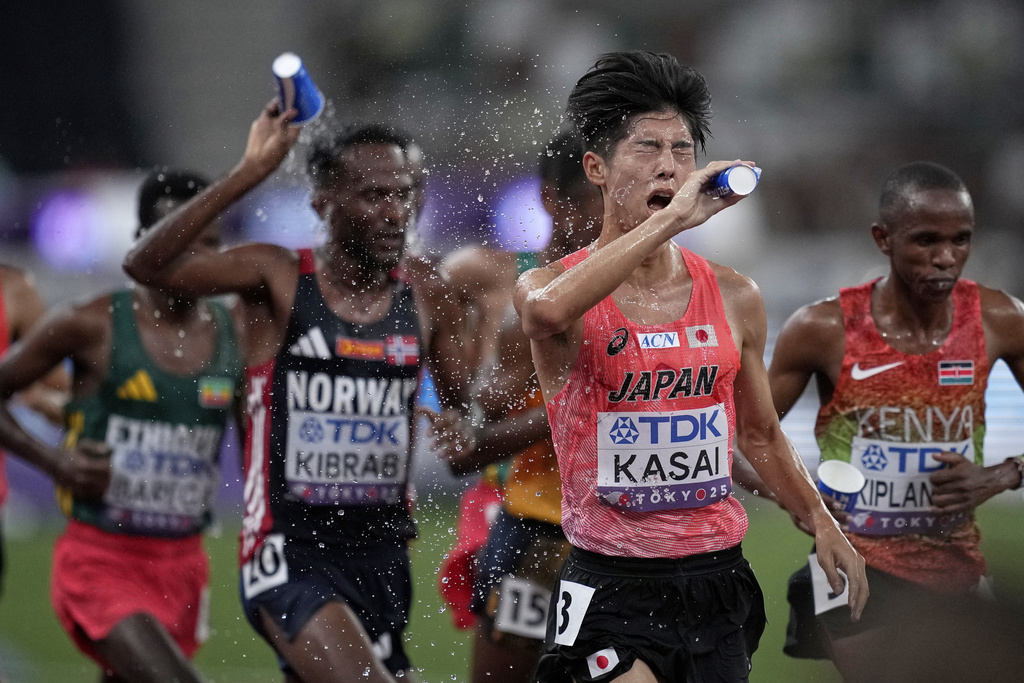 Japan's Jun Kasai douses himself with water as he races in the men's 10,000 meters final at the World Athletics Championships in Tokyo, Sunday, Sept. 14, 2025. (AP Photo/Louise Delmotte)