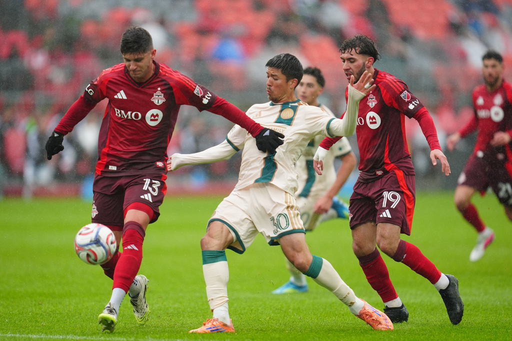 Toronto FC's Benjamín Kuscevic, left, and Atlanta United's Cayman Togashi battle for the ball during the first half of an MLS soccer game in Toronto, Saturday, April 25, 2026. (Frank Gunn/The Canadian Press via AP)