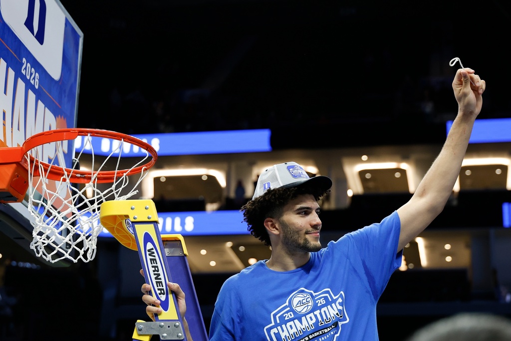 Duke forward Cameron Boozer cuts down the net after his team defeated Virginia in an NCAA college basketball game in the championship of the Atlantic Coast Conference tournament in Charlotte, N.C., Saturday, March 14, 2026. (AP Photo/Nell Redmond)