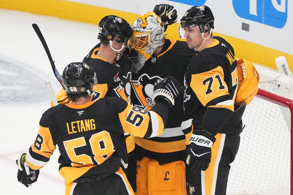 Pittsburgh Penguins goalie Marc-Andre Fleury, center, is surrounded by Kris Letang (58), Sidney Crosby, second from left, and Evgeni Malkin (71) following a pre-season NHL hockey game against the Columbus Blue Jackets in Pittsburgh, Saturday, Sept. 27, 2025. (AP Photo/Gene J. Puskar)