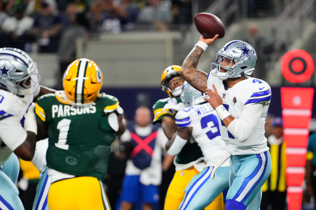 Dallas Cowboys quarterback Dak Prescott (4) throws a pass under pressure from Green Bay Packers defensive end Micah Parsons (1) in the first half of an NFL football game Sunday, Sept. 28, 2025, in Arlington, Texas. (AP Photo/Jeffrey McWhorter)