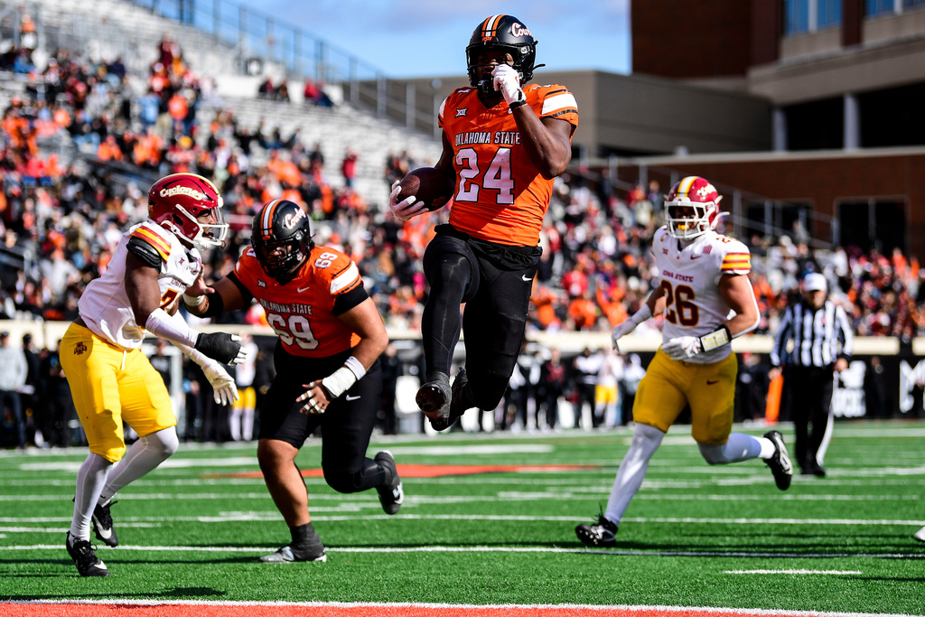 Oklahoma State running back Trent Howland (24) goes for a touchdown against Iowa State during the first half of an NCAA college football game, Saturday, Nov. 29, 2025, in Stillwater, Okla. (AP Photo/Gerald Leong)