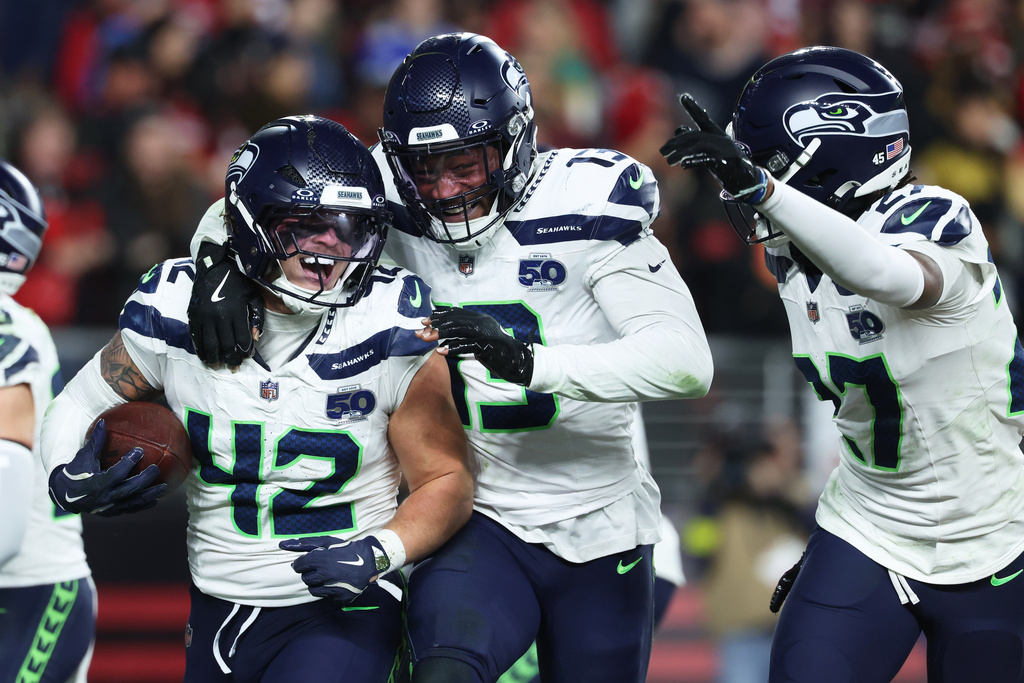 Seattle Seahawks linebacker Drake Thomas (42) is congratulated by linebacker Ernest Jones IV, middle, and cornerback Riq Woolen after intercepting a pass against the San Francisco 49ers during the second half of an NFL football game in Santa Clara, Calif., Saturday, Jan. 3, 2026. (AP Photo/Jed Jacobsohn)