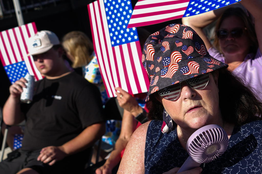 A person cools down with a portable fan ahead of President Donald Trump's speech at the opening of the Great American State Fair on the National Mall, Wednesday, June 24, 2026, in Washington. (AP Photo/Julia Demaree Nikhinson)