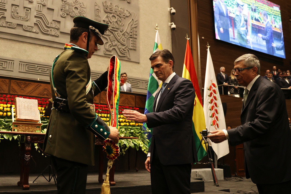 President Rodrigo Paz, right, receives the presidential sash from Vice President Edman Lara in La Paz, Bolivia, Saturday, Nov. 8, 2025. (Luis Gandarillas/Pool Photo via AP)