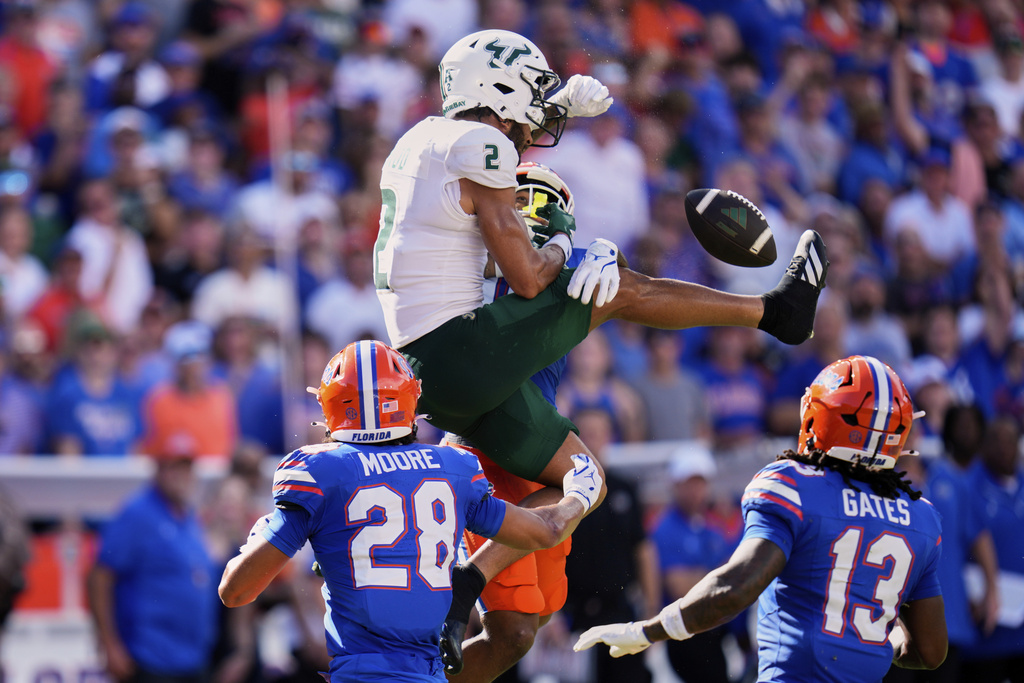 Florida defensive back Devin Moore (28) and defensive back Bryce Thornton, back, break up a pass intended for South Florida wide receiver Chas Nimrod (2) as defensive back Aaron Gates (13) looks on during the first half of an NCAA college football game, Saturday, Sept. 6, 2025, in Gainesville, Fla. (AP Photo/John Raoux)