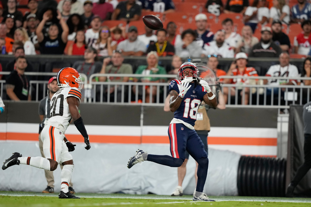 New England Patriots wide receiver Kyle Williams (18) catches a pass for a touchdown as Cleveland Browns defensive back D'Angelo Ross (20) defends during the first half of a preseason NFL football game Thursday, Aug. 27, 2026, in Cleveland. (AP Photo/Carolyn Kaster)