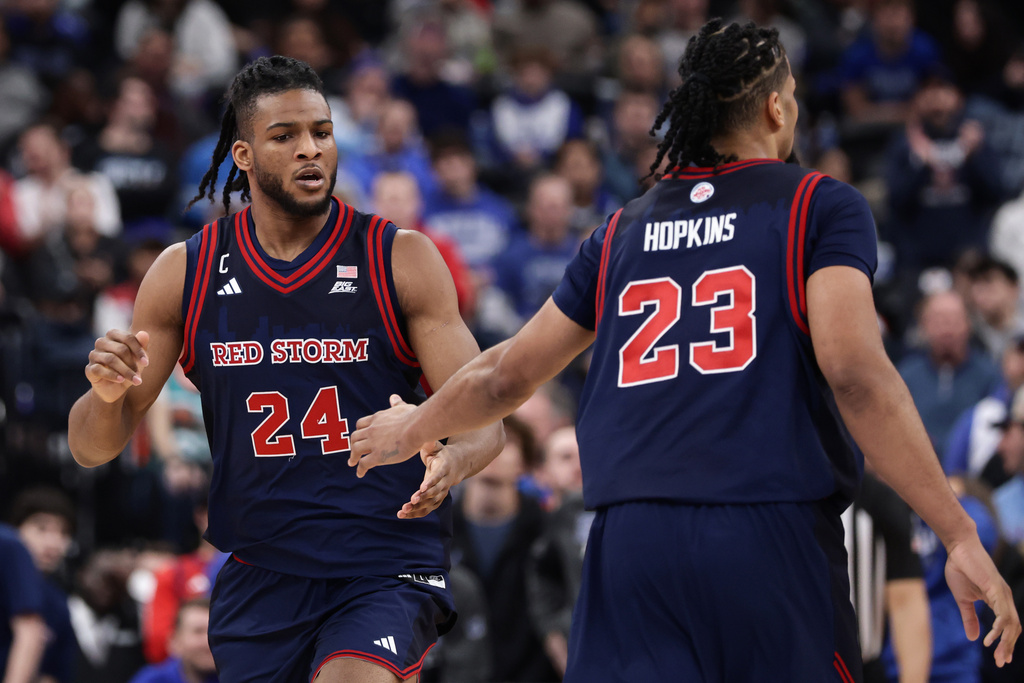 St. John's forward Zuby Ejiofor (24) is congratulated by Bryce Hopkins (23) during the second half of an NCAA college basketball game against Seton Hall, Friday, March 6, 2026, in Newark, N.J. (AP Photo/Adam Hunger)